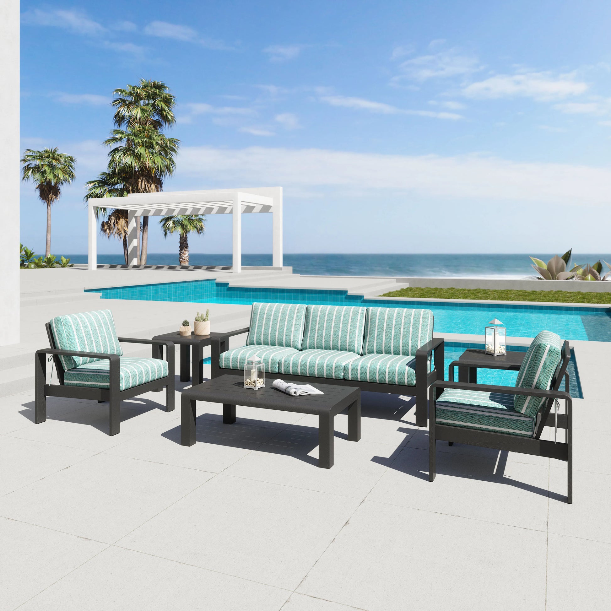 Outdoor patio furniture set with striped cushions by a poolside with palm trees and ocean view.