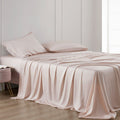 Beige bedspread and pillows on a bed in a minimalistic room.