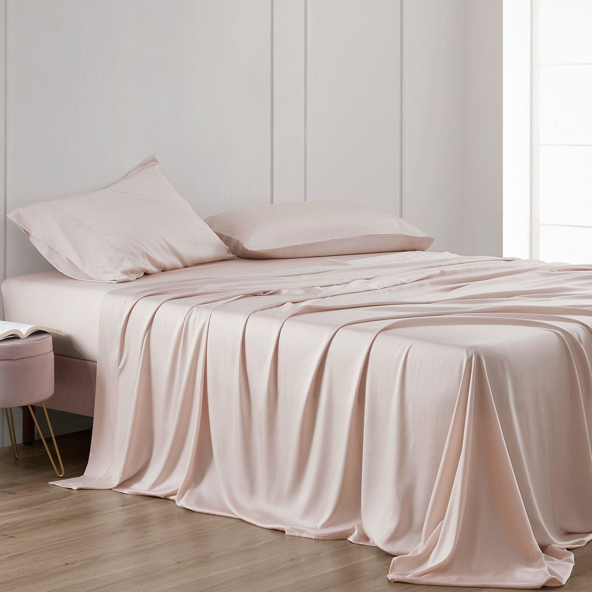 Beige bedspread and pillows on a bed in a minimalistic room.