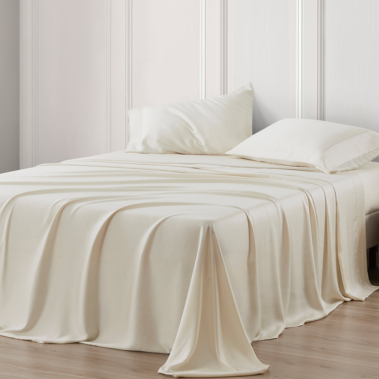 Beige bedspread and pillows on a bed with a neutral wall background
