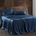 Blue satin bedding set on a bed with a wooden headboard.