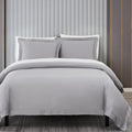Gray bedding set on a bed with a neutral background