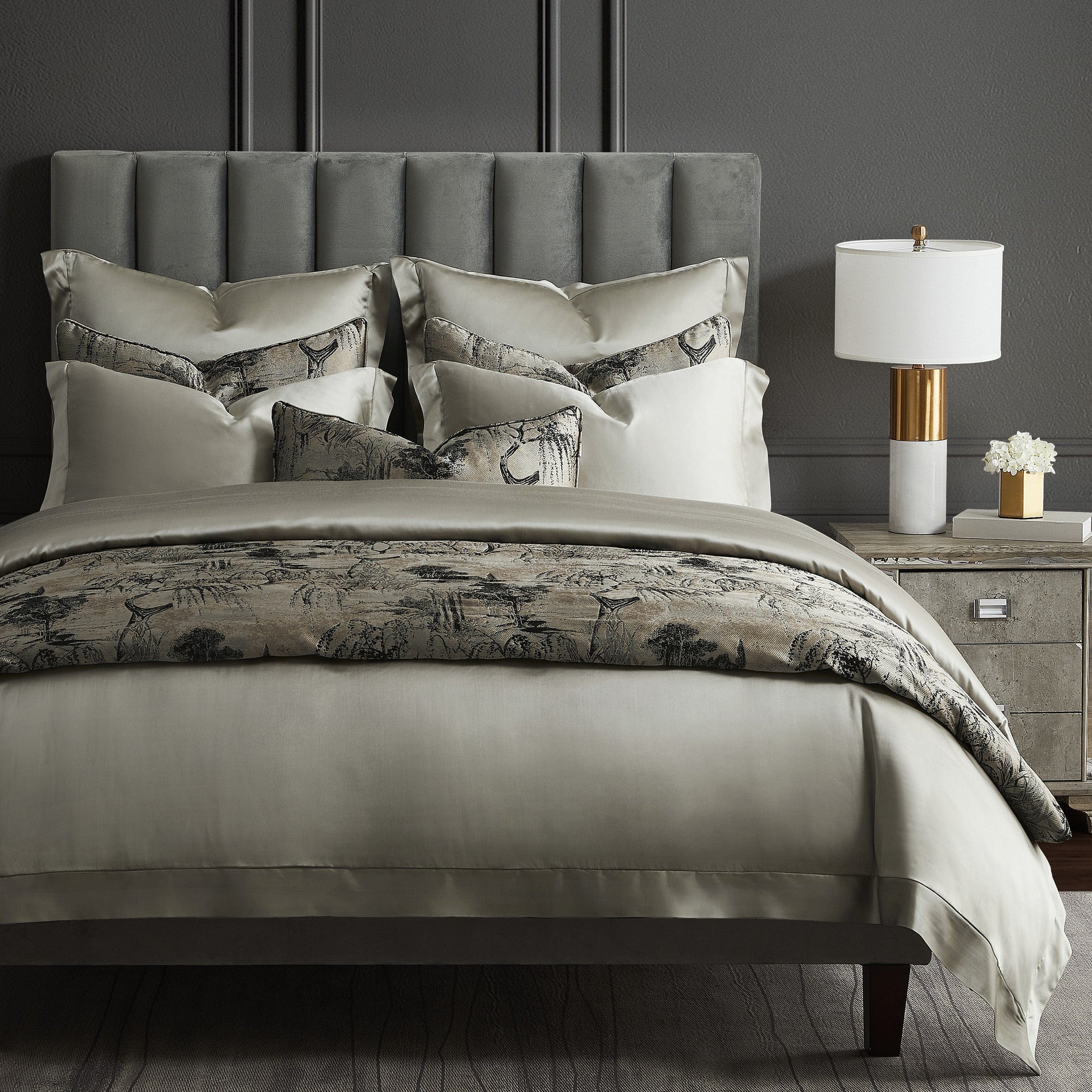 Neatly made bed with patterned duvet and pillows in a bedroom setting.