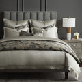 Neatly made bed with patterned duvet and pillows in a bedroom setting.