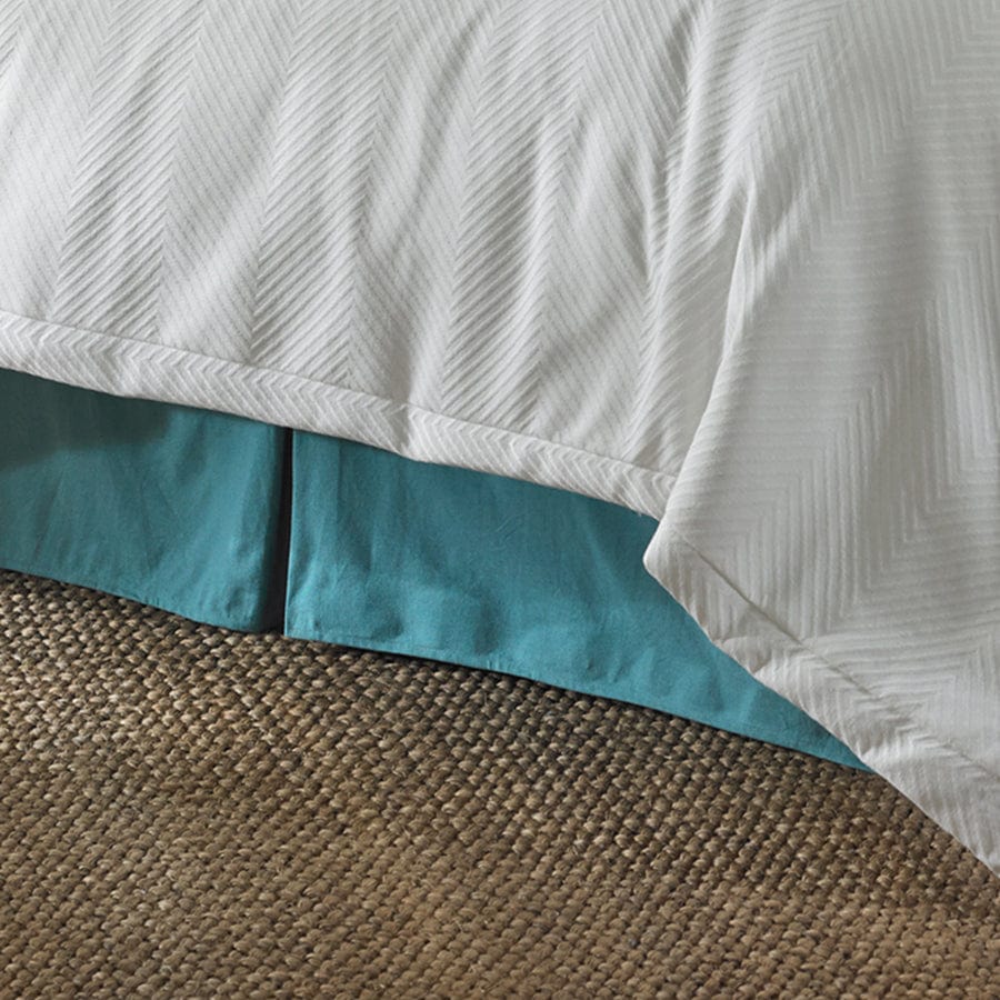 earth-toned textured bed skirt in a elegant modern bedroom setting