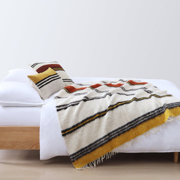 warm-toned soft decorative pillow in a refined master bedroom setting