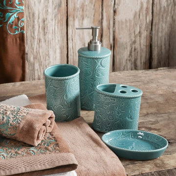 Teal bathroom accessories set on a wooden surface with towels.