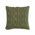 Green knitted pillow with a diamond pattern on a white background
