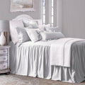Neatly made bed with white bedding in a bedroom setting.