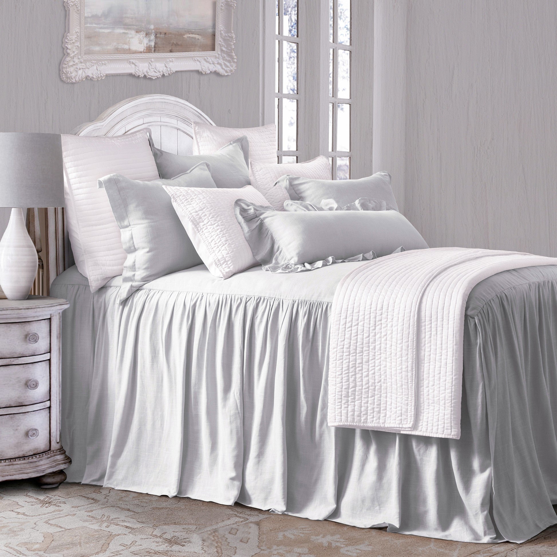 Neatly made bed with white bedding in a bedroom setting.