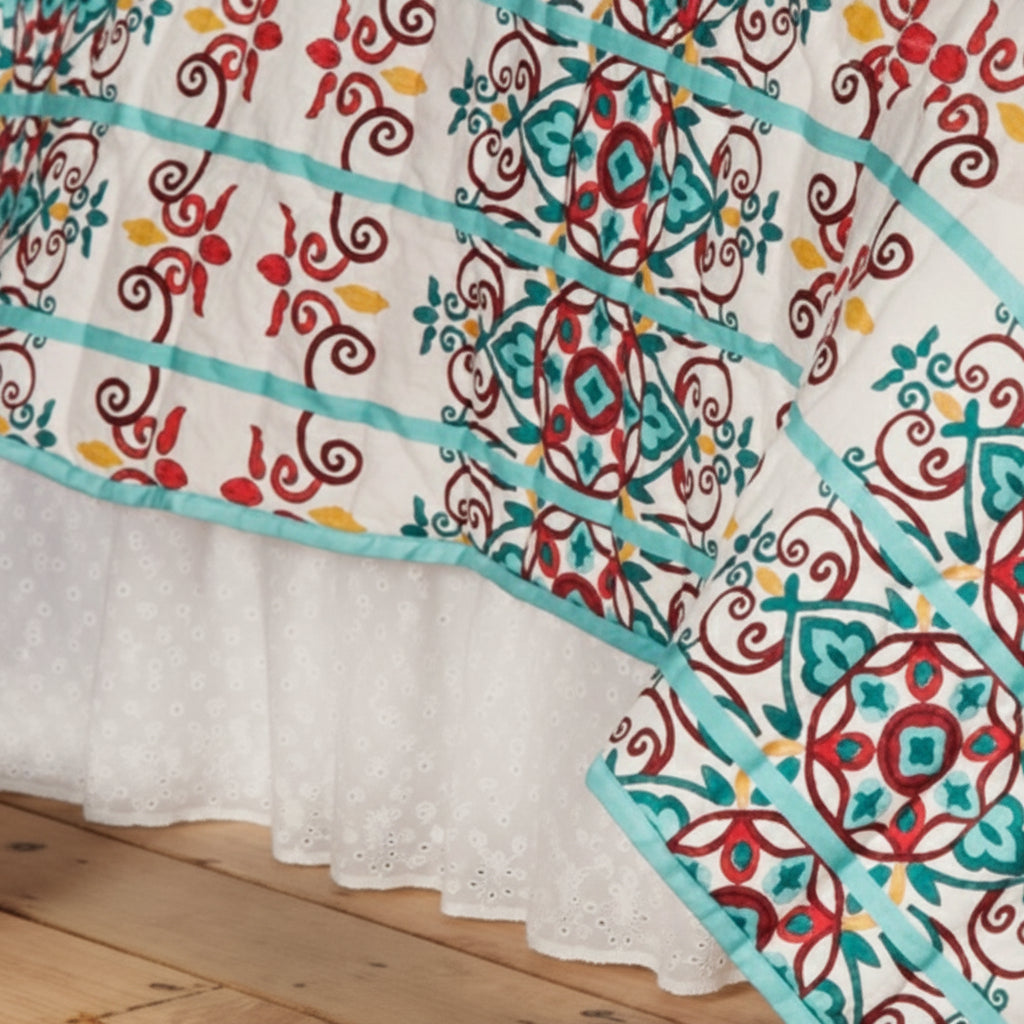 Tablecloth with colorful floral pattern on top and white eyelet design on the bottom