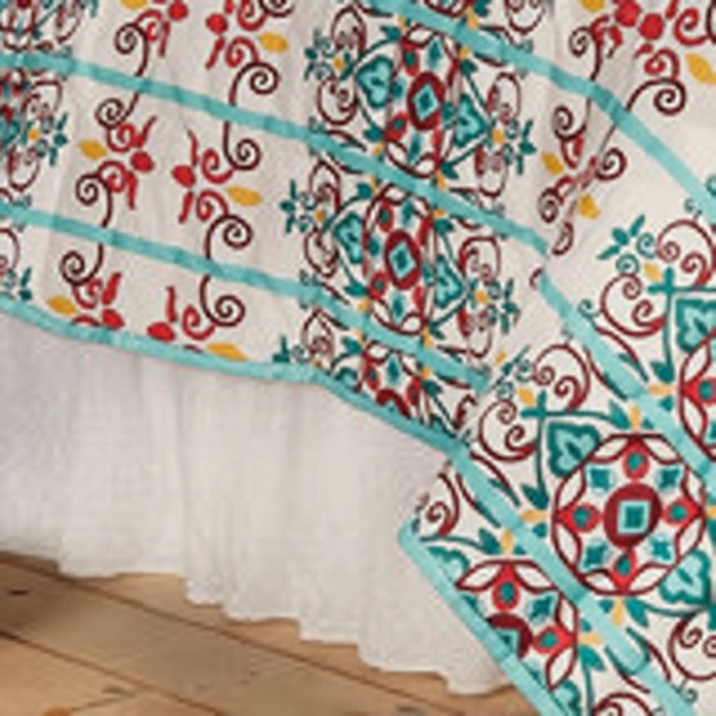 Tablecloth with colorful floral pattern on top and white eyelet design on the bottom