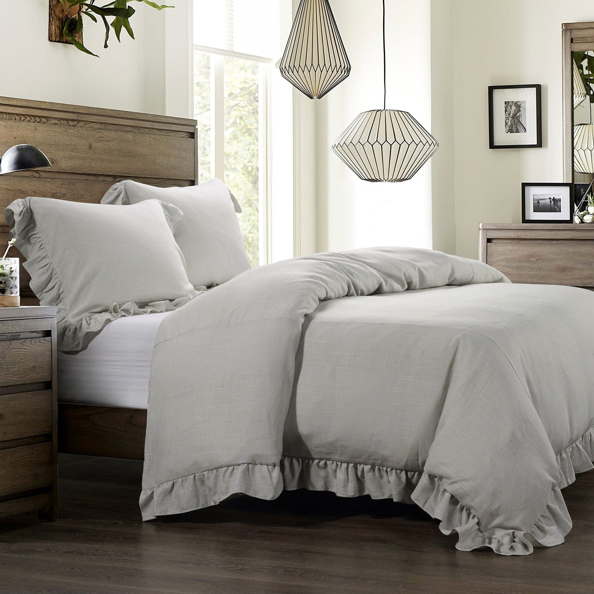 Neatly made bed with gray comforter in a bedroom setting.
