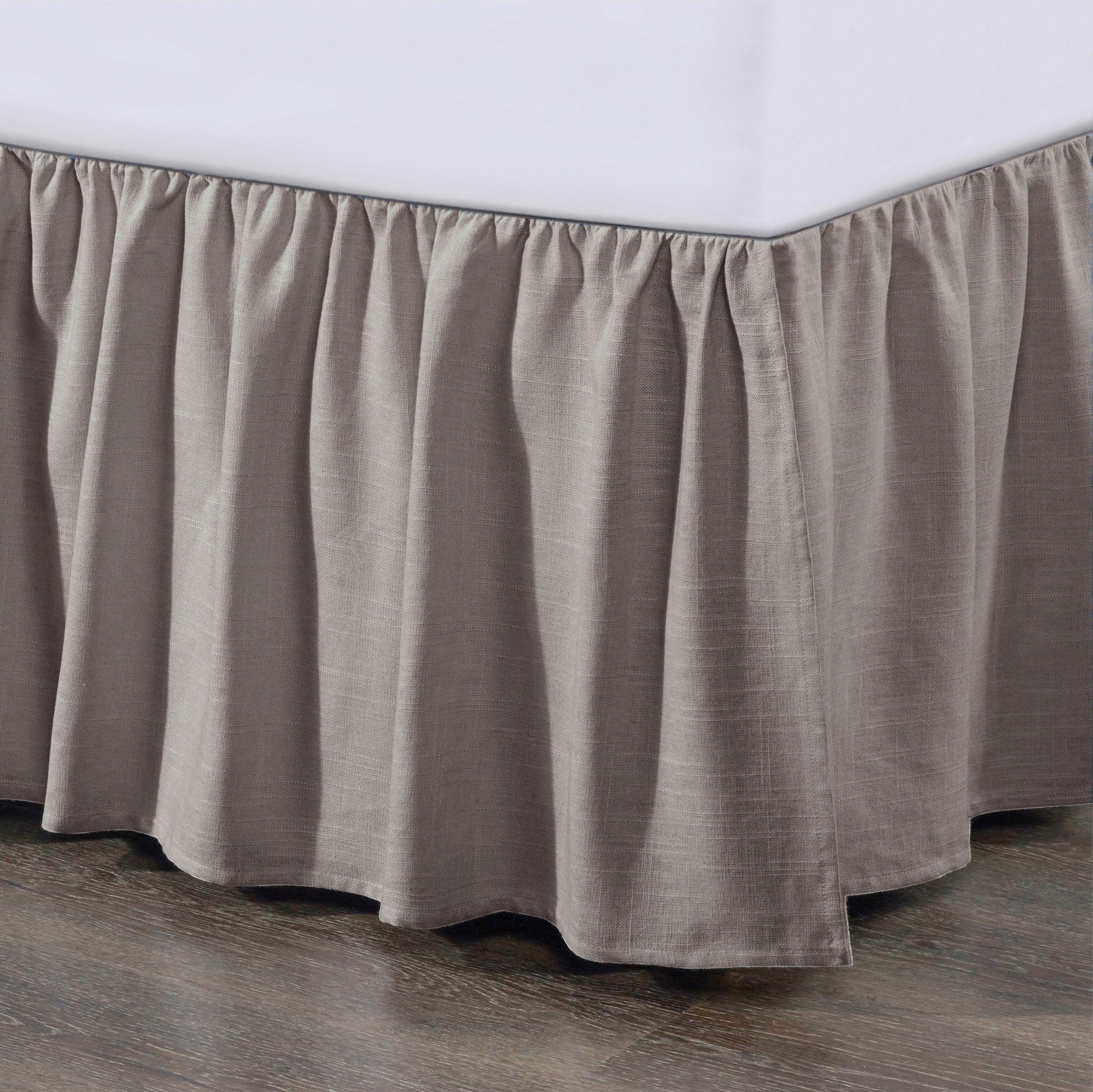 Brown bed skirt on a bed with a white mattress.