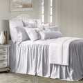 Neatly made bed with white bedding in a bedroom setting.