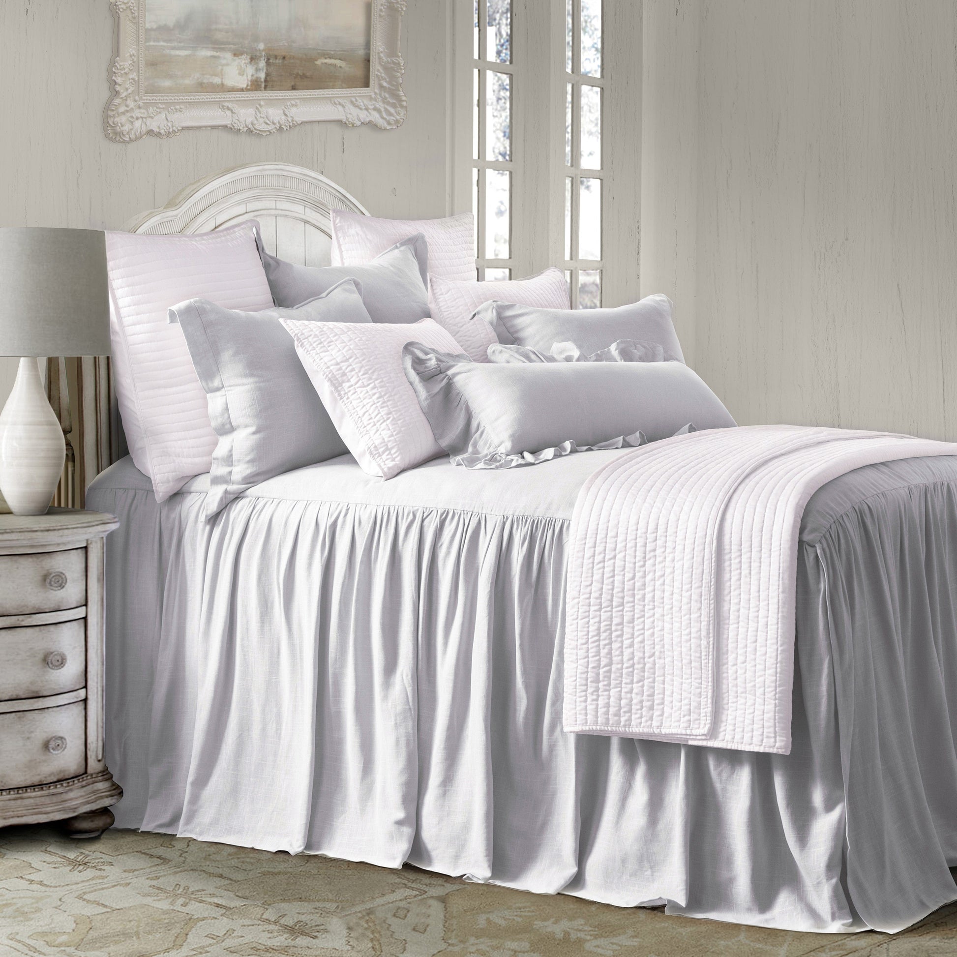 Neatly made bed with white bedding in a bedroom setting.