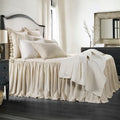 Neatly made bed with beige bedding in a bedroom setting.