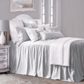 Neatly made bed with white bedding in a bedroom setting.