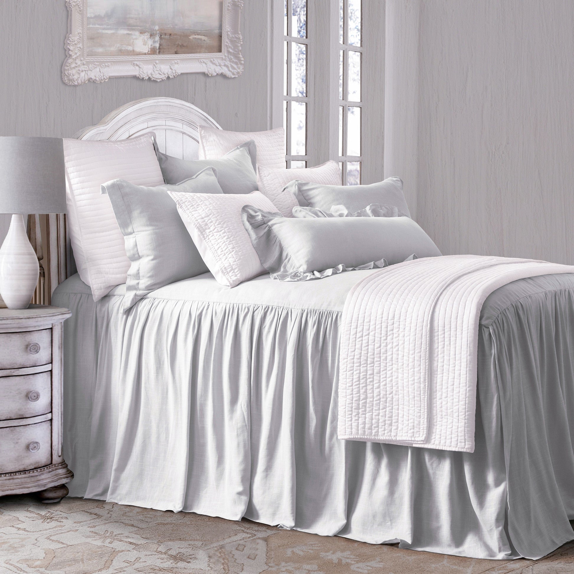 Neatly made bed with white bedding in a bedroom setting.