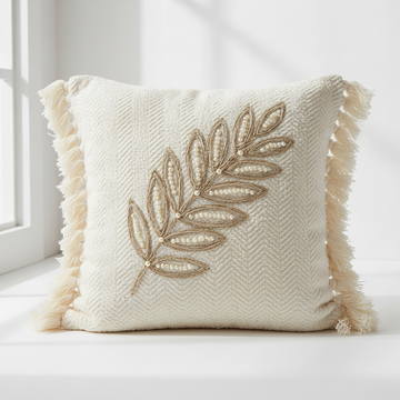 Decorative pillow with leaf embroidery and tassels on a white background