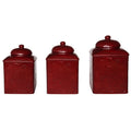 Set of three red ceramic canisters with embossed designs on a white background